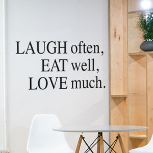 Sticker mural Laugh Often décoration à côté d'une étagère dans une pièce à vivre