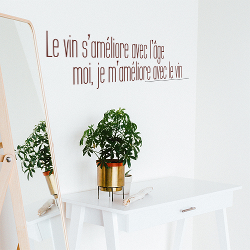 Sticker mural citation Le vin s'améliore dans un salon à côté d'une plante et d'un miroir