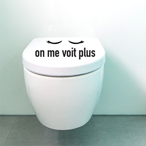 Toilettes blanches avec un sticker citation On me voit