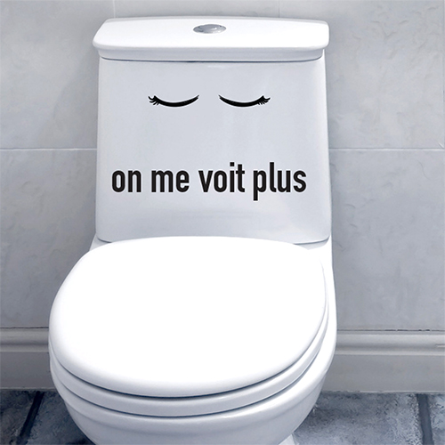 Salle de WC moderne grise avec un sticker citation On me voit plus