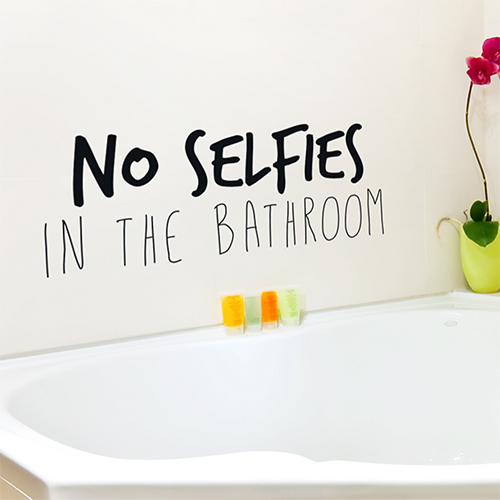 Baignoire moderne surplombée d'un sticker citation No selfies in the bathroom