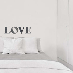 Sticker citation LOVE collé dans une pièce à vivre grise et moderne