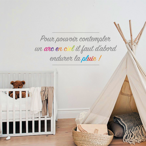 Sticker adhésif Arc en ciel posé sur un mur de chambre d'enfant avec un lit et un tipi