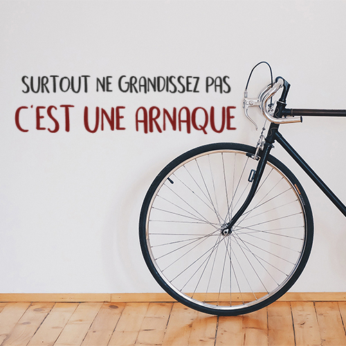 Sticker adhésif surtout ne grandissez pas posé sur un mur avec un vélo