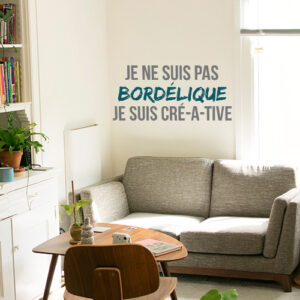 Sticker mural Je ne suis pas bordélique au dessus d'un fauteuil dans un salon