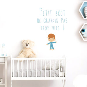 Sticker "petit bout ne grandis pas trop vite" au dessus d'un lit de bébé