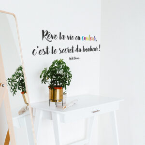 Sticker autocollant "rêves la vie en couleur, c'est le secret du bonheur" collé au mur au dessus d'une table