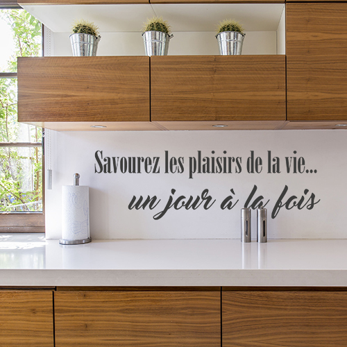 Sticker citation pour cuisine savourez les plaisirs collé au mur d'une cuisine