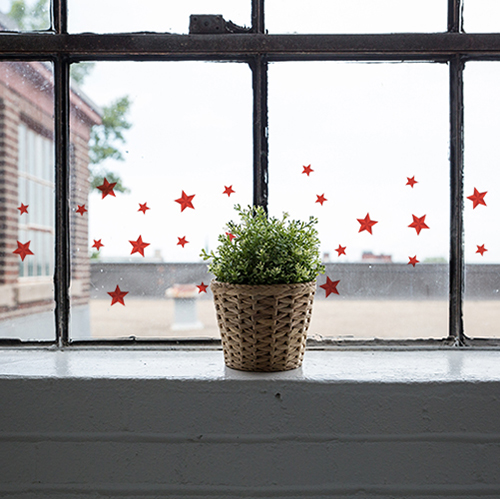 Stickers électrostatiques pour fenêtres de Noël étoile rouge sur la fenetre d'une maison vintage pour une déco de fêtes.