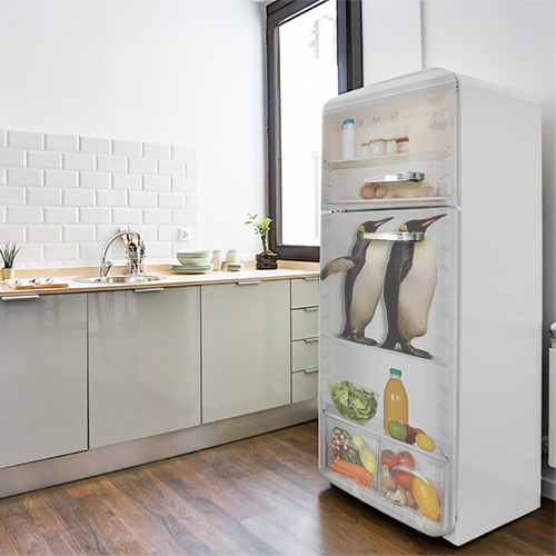 Sticker décoratif pinguin dans un frigo collé sur la porte d'un grand frigo