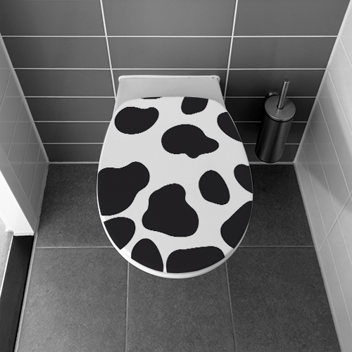 Salle de bain avec des WC ornés d'un motif autocollant taches de vaches