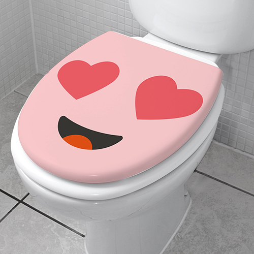 Sticker autocollant de la gamme Smiley : Smiley amoureux rose collé sur des toilettes blanche