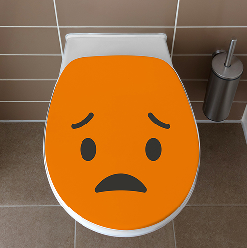 Abattant de WC avec un sticker déçu orange collé dessus
