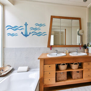 Sticker ancre bleue sur mur de salle de bain aux meubles de bois