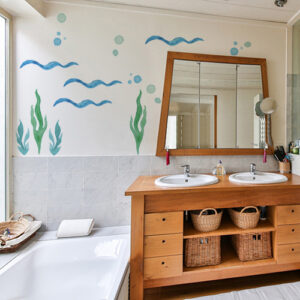 sticker algues en déco sur le mur d'une salle de bain avec des meubles en osier