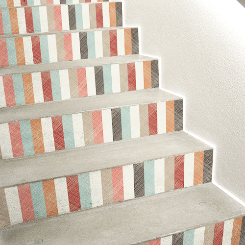 Escalier en béton blanc avec des stickers adhésifs multicolores collés sur les contremarches.