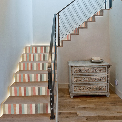 Escalier standard en bois avec des bandes multicolores collées sur les contremarches