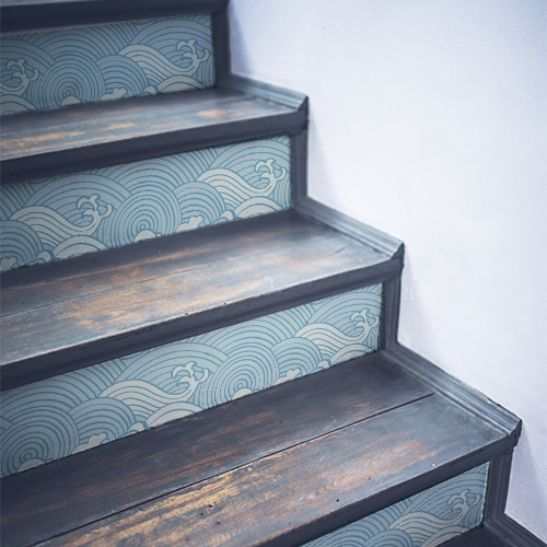 Vagues dessinées avec un style asiatique décorant les contremarches d'un escalier en bois noir