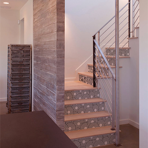 Stickers décoratifs représentant des cercles blancs collés sur les contremarches d'escaliers en bois dans une maison moderne