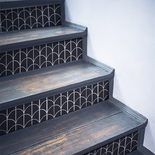 Escalier en bois noir avec des stickers noirs et blancs collés sur les contremarches