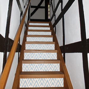 Escaliers traditionnels avec des stickers adhésifs bleus clair et blancs collés sur les contremarches