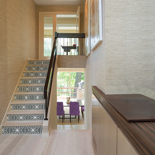 Maison moderne dont les escaliers en bois sont décorés par des stickers autocollants noirs représentant des formes géométriques