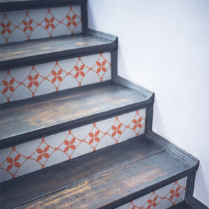 Escalier en bois noir décoré avec des stickers autocollants imitation céramique blanche et orange