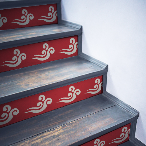 Sticker adhésif nuages blancs sur fond rouge collés sur un escalier classique en bois