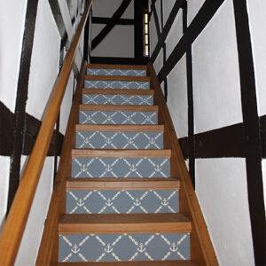 Maison traditionnelle dont les escaliers sont mis en valeurs avec des stickers autocollants représentant des ancres blanches sur fond bleu