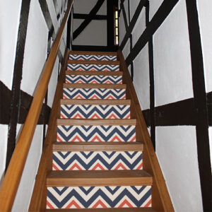 Escalier traditionnel dont les contremarches sont décorés par des stickers autocollants chevrons bleus blancs rouges