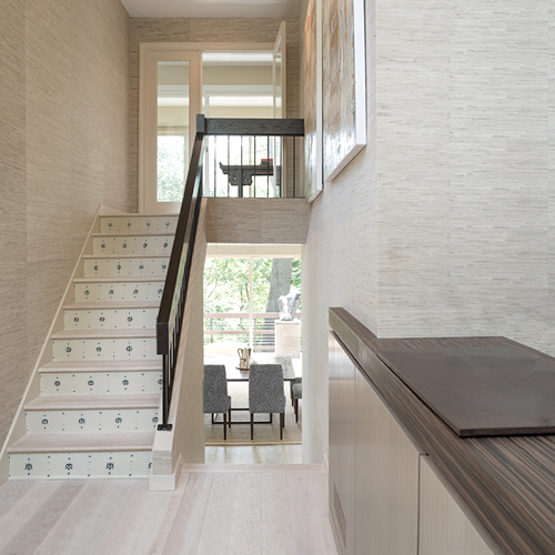 Escalier en bois décoré avec des stickers adhésifs représentant des gouvernails de bateau noirs sur fond blanc