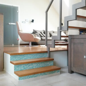 Maison moderne avec des escaliers en bois ornés de stickers adhésifs représentant des vagues bleues claires