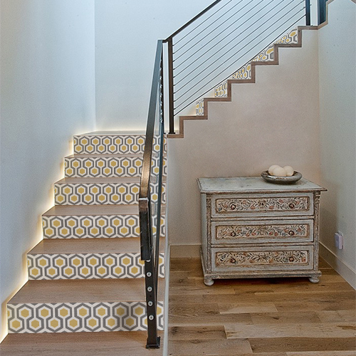 Maison moderne avec des stickers ruches grises et jaunes collés sur les contremarches de l'escalier