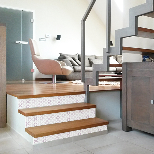 Décorer un escalier en bois clair avec des contremarches adhésives de style oriental dont le motif de rosace à la manière des cramique est moderne en camaïeu de rose.