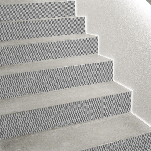 Tiroirs de commode et décoration d'escalier avec des stickers adhésifs de contremarches chevrons 3D gris et blanc.