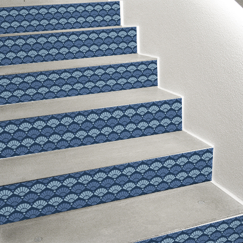 Sublimez votre déco marine dans les escaliers grâce aux contremarches adhésives écailles sirène représentant des coquillages en quinconce et en camaïeu de bleus.