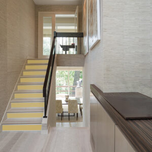 Un escalier moderne illuminé par des contremarches d'escalier adhésive aux tons jaune curry.