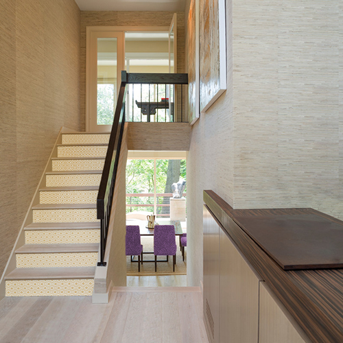 Cage d'escalier maison moderne avec contremarches personnalisées au motif ethnique losange doré.