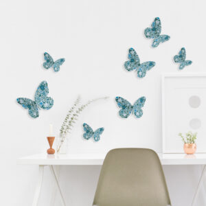 Sticker mural adhésif 3D papillons bleu collés sur un mur blanc