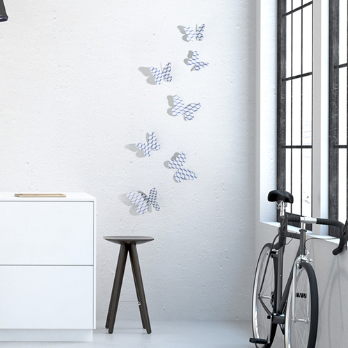 Sticker Papillons scandinave chevrons 3D sur un mur de salon avec un vélo et un meuble de salon