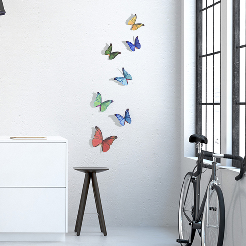 Stickers muraux Papillons multicolores déco sur un mur blanc avec un vélo