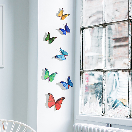 Sticker autocollant représentant des papillons multicolores sur un rebord de fenêtre