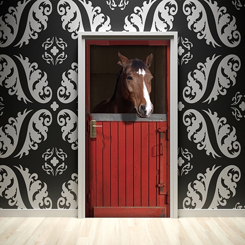 Grand studio aux murs blancs décoré avec un sticker frise géométrique dorée et blanche collée sur la porte.