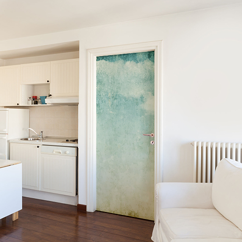 Cuisine moderne blanche dont la porte est décoré avec un sticker autocollant mer turquoise