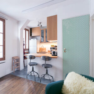 Maison moderne avec des murs bleus et un sticker vert à pois blanc collé sur la porte ambiance bois métal cosy cocooning douillet