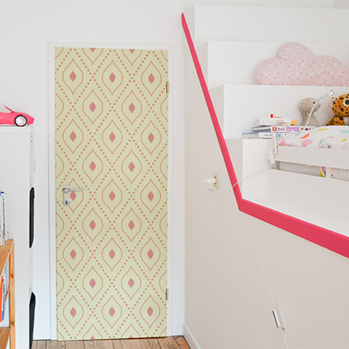 Chambre d'enants décorée avec un sticker motif rouge sur fond jaune collé sur la porte