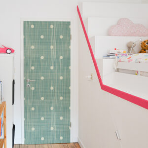 Chambre pour enfants dont la porte est décorée par un sticker autocollant décoratif vert à pois blancs