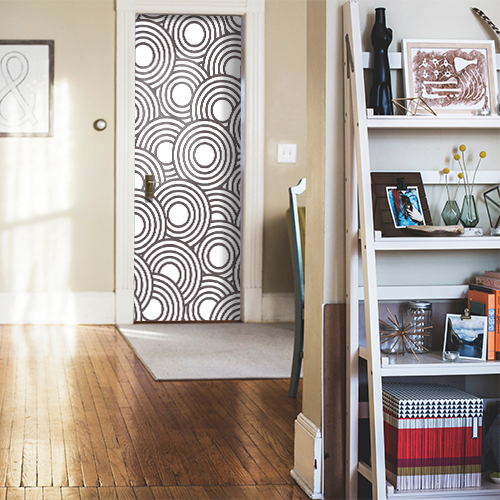 Porte d'entrée d'une maison familiale qui est décorée avec un sticker pour porte modèle ronds blancs et noirs