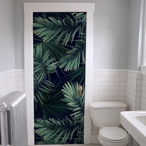 Salle de bain transformée avec un adhésif fougère sur fond noir motif fougères vertes sur fond noir collé sur la porte