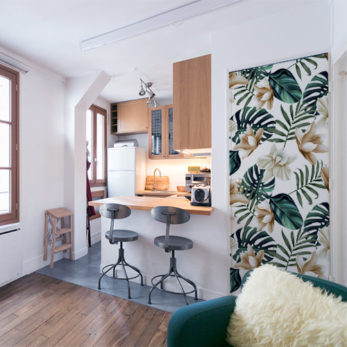 Studio moderne de style industriel avec porte personnalisée par une adhésif déco de porte jungle au motif monstera et lotus avec un léger filtre vintage.